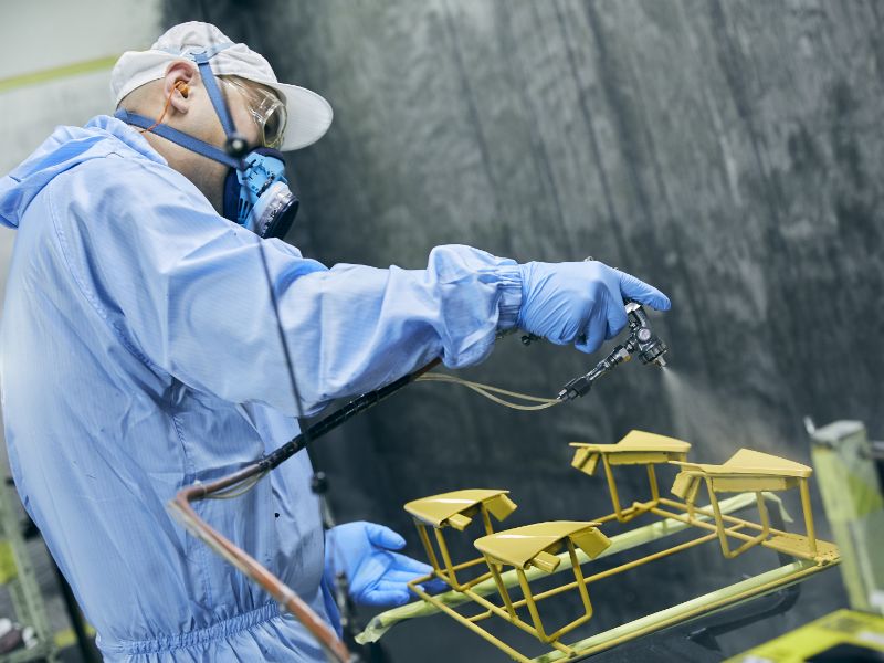 職人が手作業で塗装を吹きかける写真